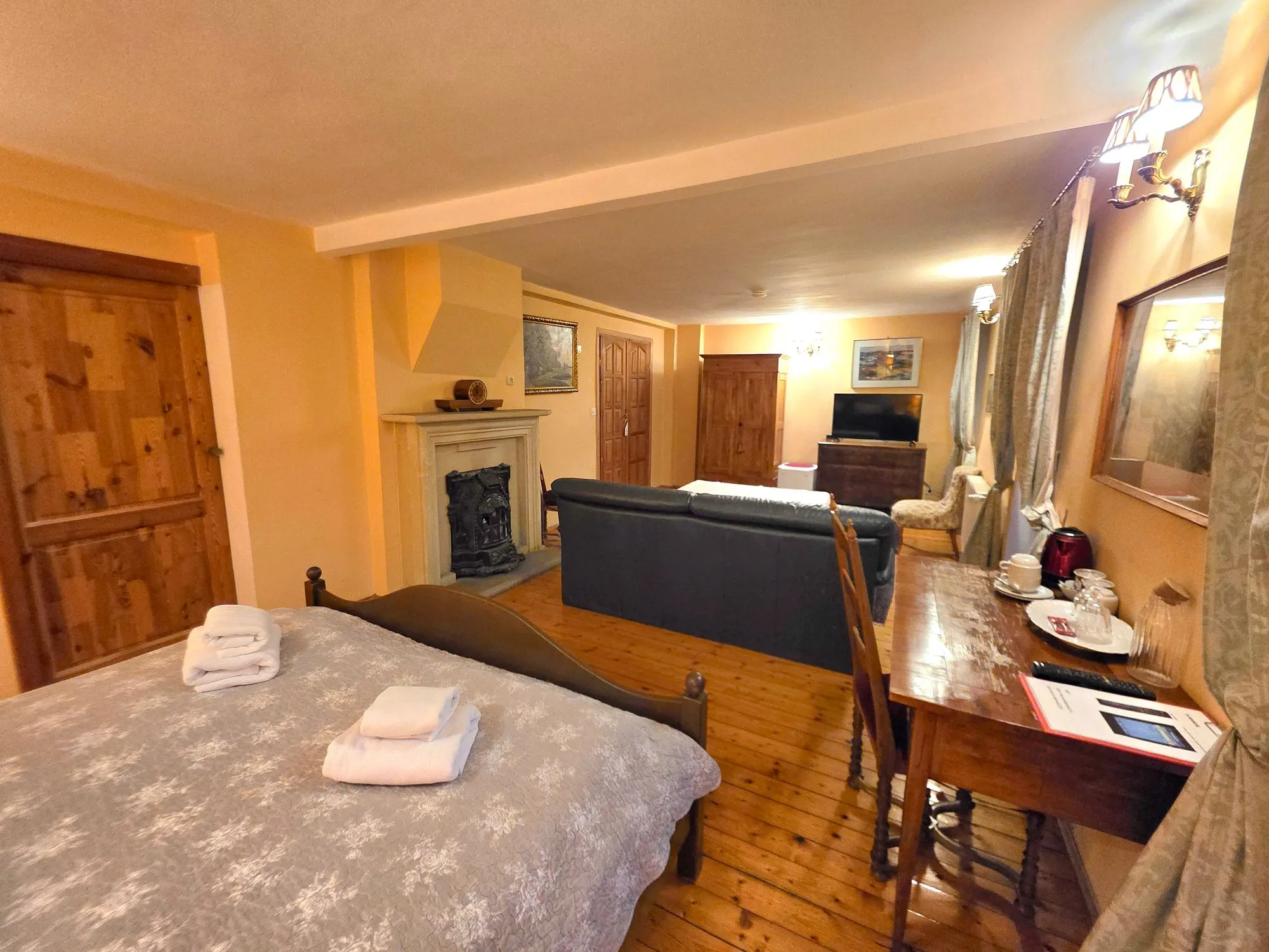 Junior Suite mit Bett, offenem Kamin und Schreibtisch