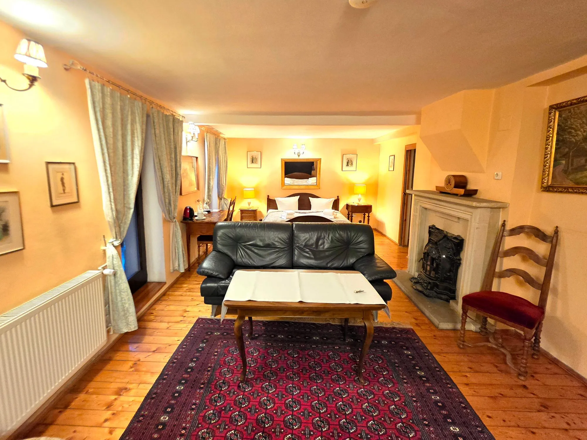Sitzbereich der Junior Suite mit Ledersofa und Kamin