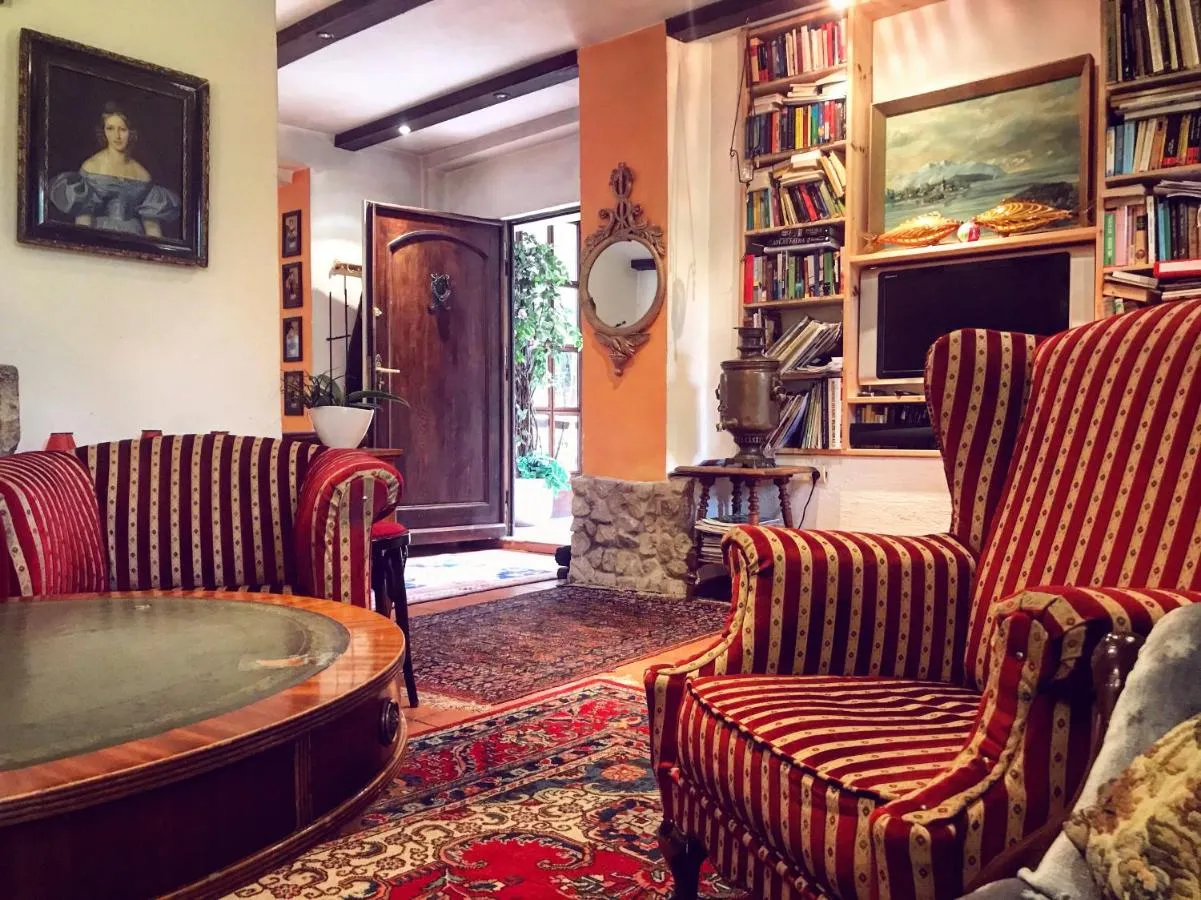 Salon mit Sofa, Gemaelden und Fenster zum Garten