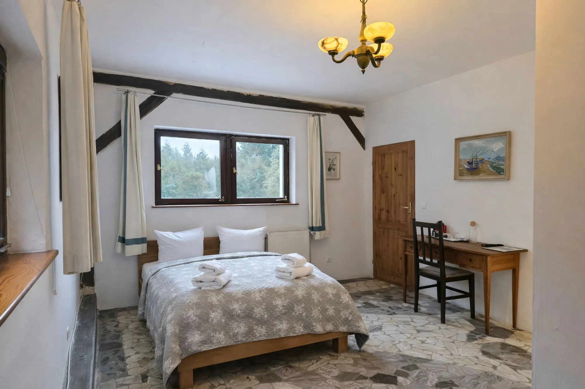 Doppelzimmer mit Kronleuchter und Blick ins Gruene
