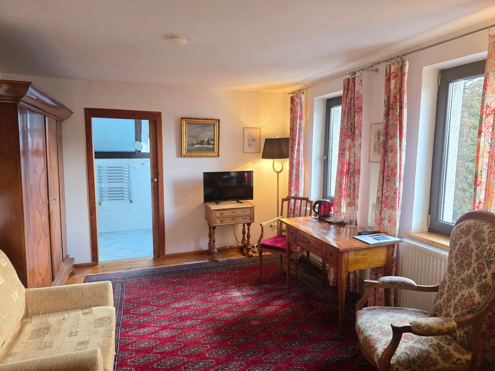 Zweibettzimmer mit Sitzecke und rotem Teppich