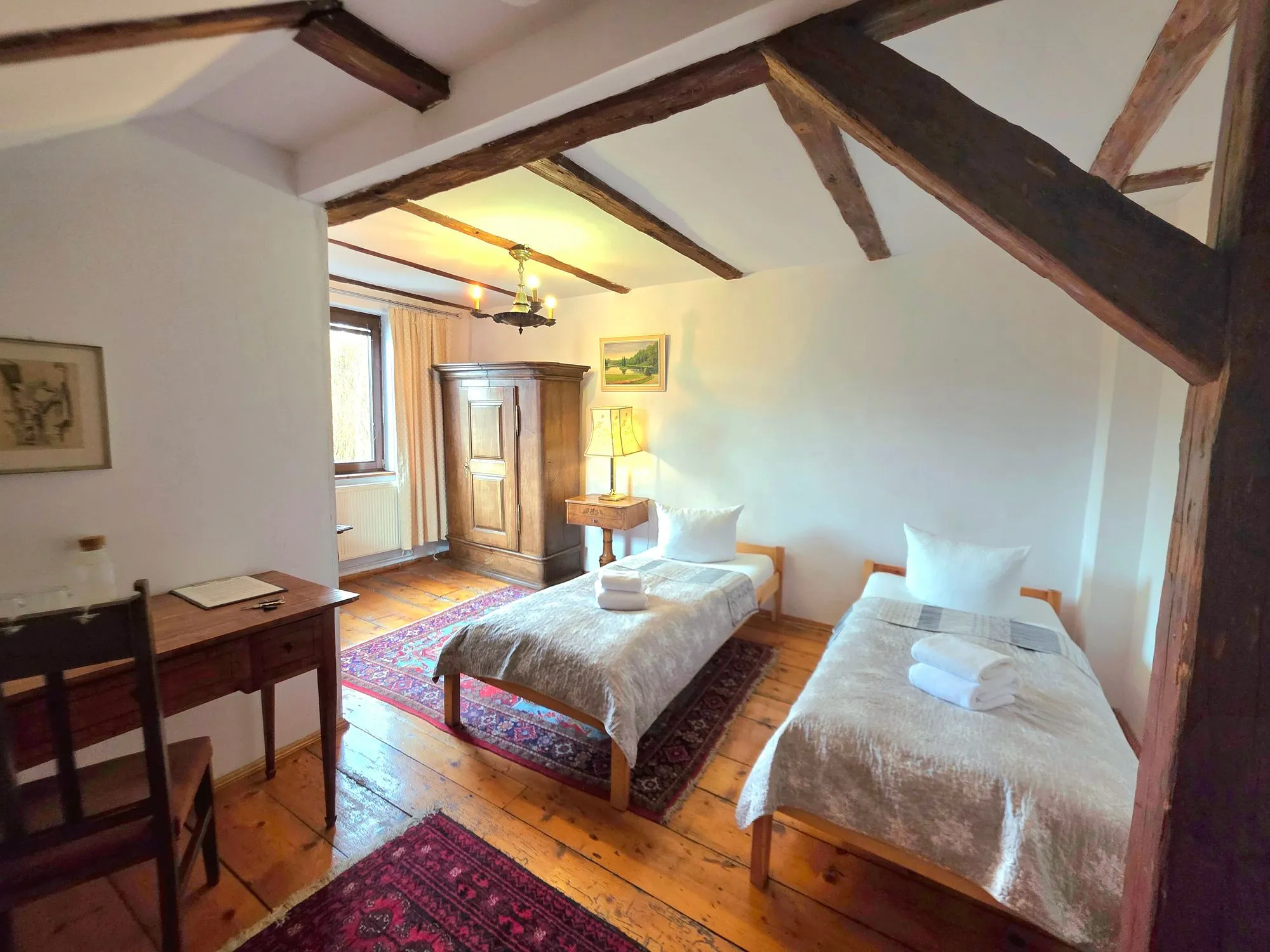 Zweibettzimmer mit Dachschraege und historischen Holzbalken